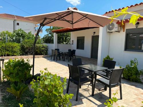 a patio with a table and chairs under an umbrella at Calliopi's studio in Plytra