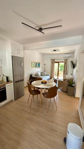 a kitchen and a living room with a table and chairs at Edem Haven Luxury Apartment in Skala Fourkas