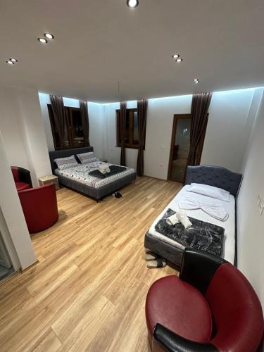 a living room with two beds and a chair at Guesthouse Dritan Selimaj in Valbonë