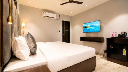 a bedroom with a bed and a flat screen tv at Hotel Jewels at Rajpur Road in Dehradun