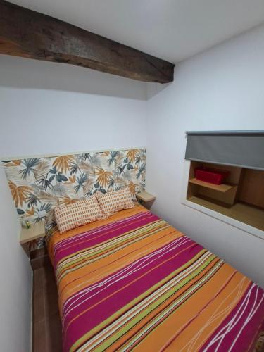 a bedroom with a bed with a colorful blanket at Apartamento en Casa Celia in Orol