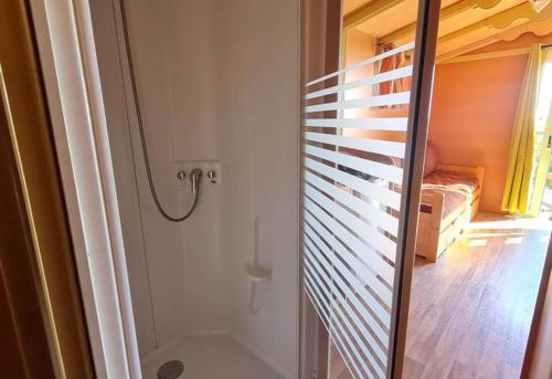 a bathroom with a walk in shower next to a bedroom at Roulotte tout confort au milieu des animaux in Burthecourt-aux-Chênes