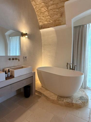 a bathroom with a large white tub and a sink at Tenuta Legaro in Cozzana