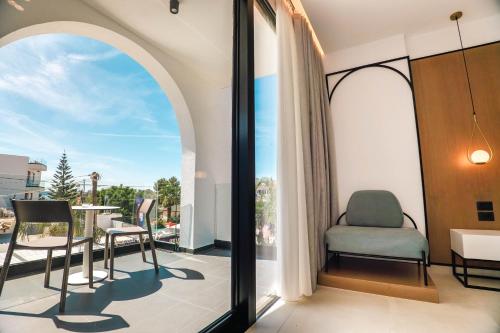 a room with a balcony with a table and chairs at Colosseum Hotel in Ksamil