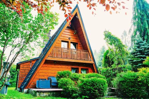 a small wooden house with a porch and a balcony at Góralski domek z kominkiem w dużym ogrodzie pełnym zieleni w spokojnej okolicy, blisko atrakcji Podhala in Łopuszna