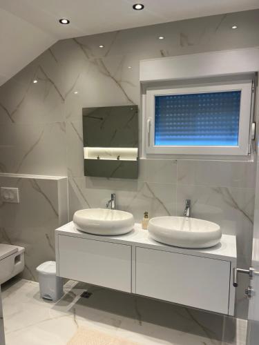 a bathroom with two sinks and a mirror at Villa Vildana in Sarajevo