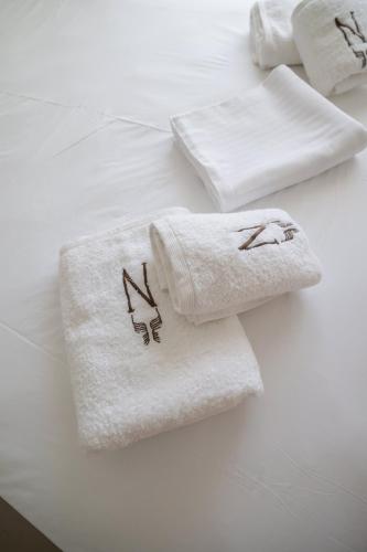 Zwei Handtücher liegen auf einem Bett. in der Unterkunft Noema Hotel in Syvota
