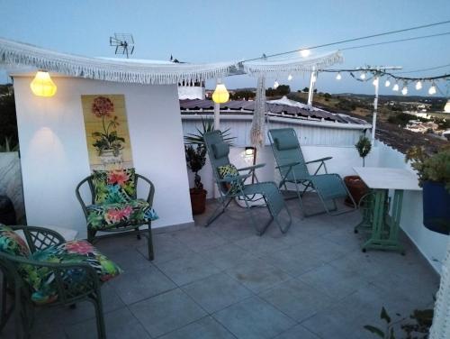 a patio with chairs and a table on a roof at Casa da Muralha in Estremoz