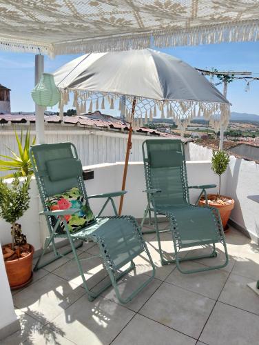 two chairs and an umbrella on a patio at Casa da Muralha in Estremoz