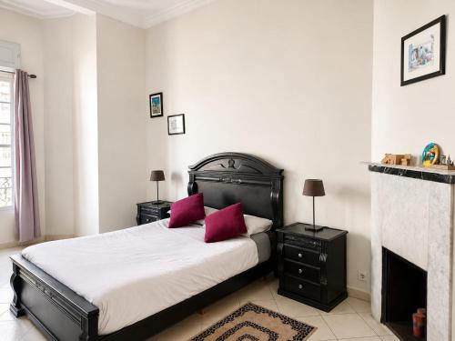 a bedroom with a bed with red pillows and a fireplace at Cosy Art Deco Apart Welcome to James's in Casablanca