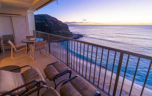 a balcony with chairs and a view of the ocean at Oceanfront Corner Unit , Hawaiian Princess in Waianae