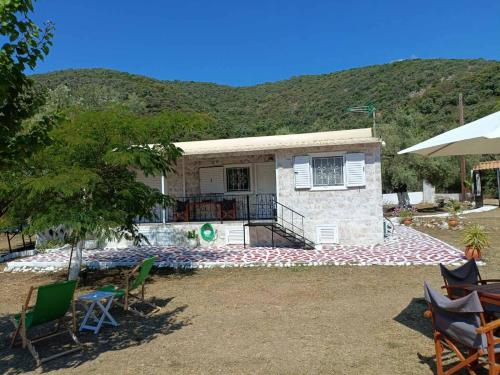 a house with a pool in front of a mountain at Helios Beach House in Mikros Gialos