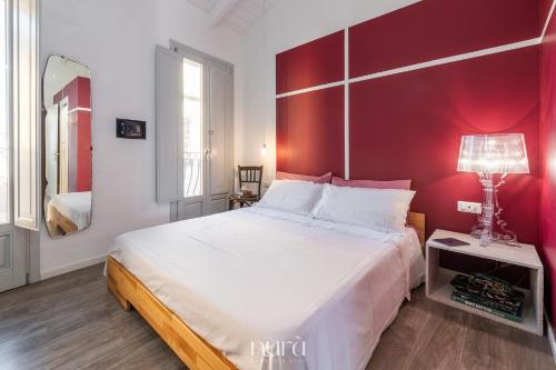 a bedroom with a large bed with a red wall at Wine Passion Room in Quartu SantʼElena