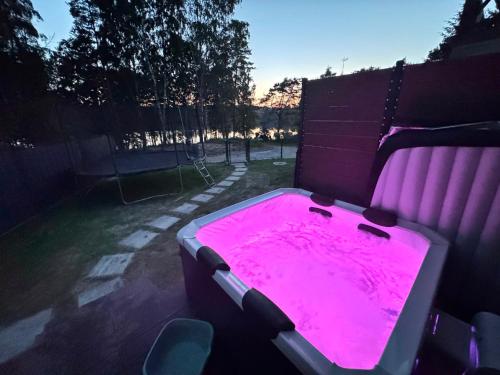 a hot pink bath tub in a backyard at Domek na Kaszubach nad jeziorem Kamień - Prywatne Jacuzzi i Rowerek Wodny in Kamień