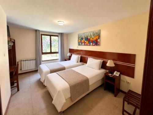 a hotel room with two beds and a window at Hotel Sol Natura in Ollantaytambo