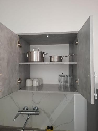 a kitchen with two pots and pans on a shelf at Keur Moussa in Dakar