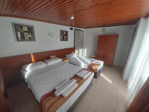a large bedroom with two beds and a wooden ceiling at London House Hotel in Kemer