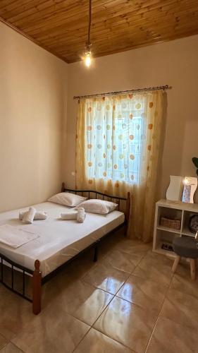 a bedroom with a bed with a curtain and a window at Todos home in Amalias