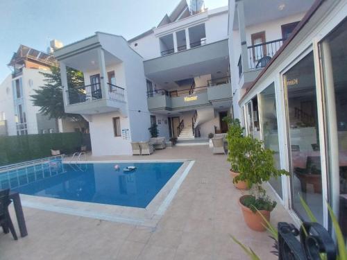 a house with a swimming pool next to a building at London House Hotel in Kemer