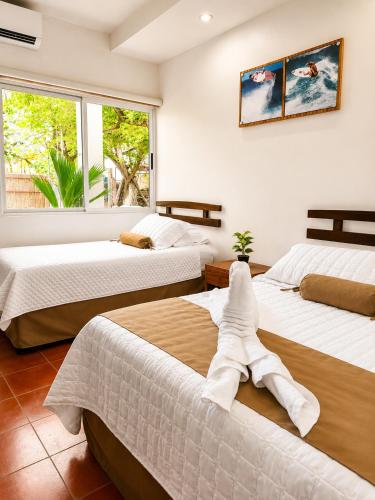 a bedroom with three beds with towels on them at Hotel Yaltas Inn in Tola