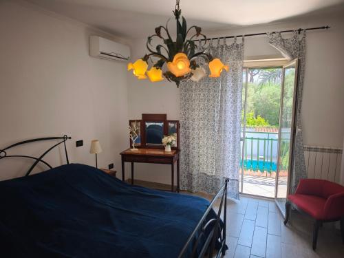 a bedroom with a bed and a window and a chandelier at La casetta di Daniela in Sabaudia