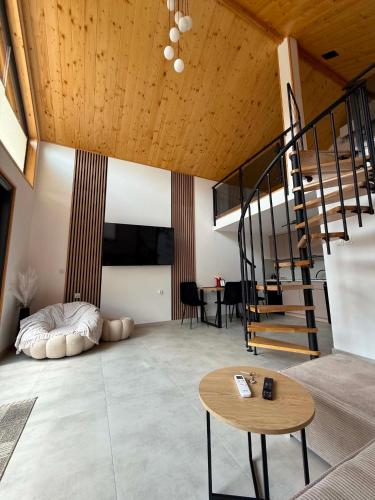 a living room with a spiral staircase and a table at Stodoła Nad Dunajcem in Sromowce Wyżne