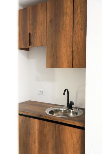a kitchen counter with a sink and wooden cabinets at Nuvelle Boutique Hotel in Prizren