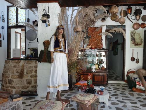 a woman standing in a room with a room filled with items at Edward Lear - Heritage Guest House in Berat