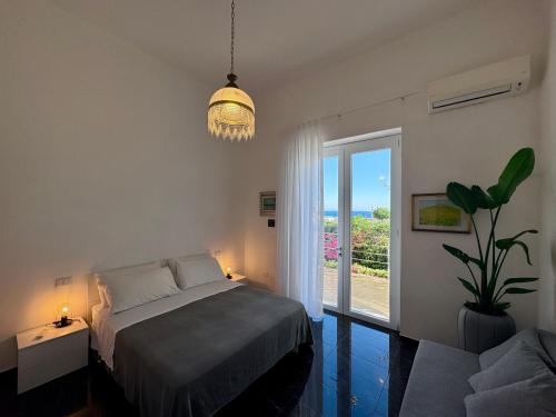 a bedroom with a bed and a large window at Villa Nauna - Beachfront Villa with Garden & Sea-View Terrace Santa Caterina - Marea Stays Collection in Nardò