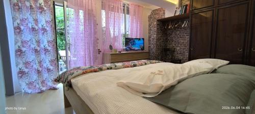 a bedroom with a large bed with pink curtains at Apartma REA Izola, pergola & terassa, parking in Izola