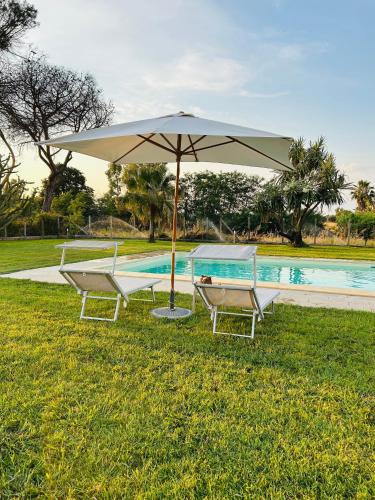 two chairs and an umbrella next to a pool at Serenity House Latina in Latina