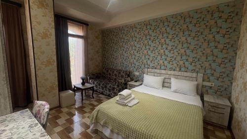 a bedroom with a bed and a couch in it at Hotel New Royal in Tbilisi City
