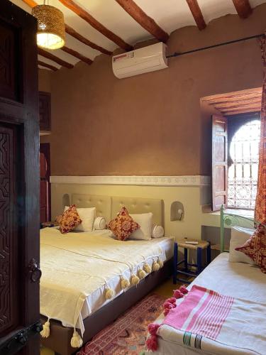 a bedroom with two beds and a window at dar boumida in Lalla Takerkoust