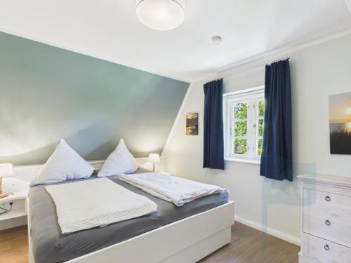 a bedroom with a bed and a desk and a window at Ferienwohnung Goting in Goting