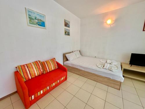 a room with a bed and a red chair at Menada Apartments in Sunny Beach in Sunny Beach