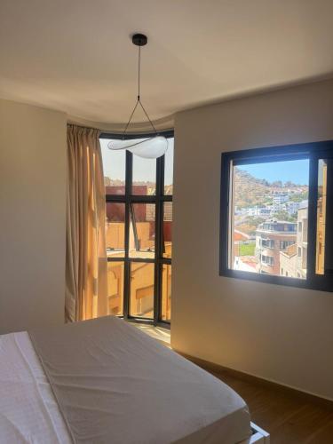 a bedroom with a bed and a large window at Belle cote appartement al hoceima in Al Hoceïma