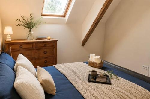 a bedroom with a bed with a dresser and a window at Le Noble Jardin in Mohon