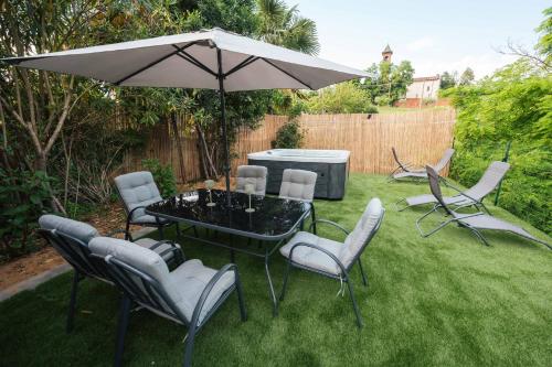 a table and chairs under an umbrella in a yard at Fermata Sessant in Asti