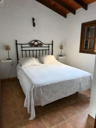 a bedroom with a large bed with a white blanket at Finca Nim 1 in Mogán