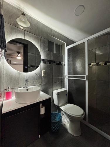 a bathroom with a sink and a toilet and a mirror at Tiny House Molino Alto in Ciudad Fernández