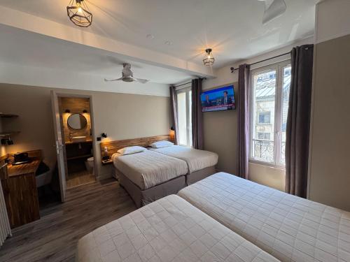 ein Hotelzimmer mit zwei Betten und einem Fenster in der Unterkunft Angleterre Hotel in Paris