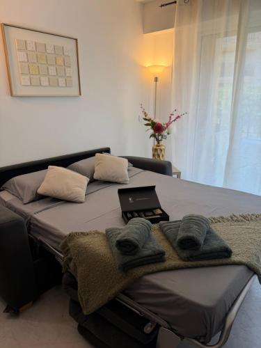 a bedroom with a bed with a laptop on it at Victoria Palace T2 de 50m2 in Menton