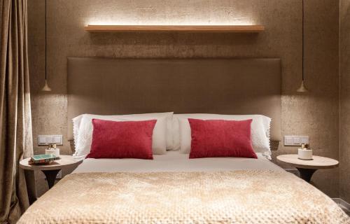 a bedroom with a large bed with two red pillows at Villa Birdie Boutique - Adults Only in Donostia-San Sebastián