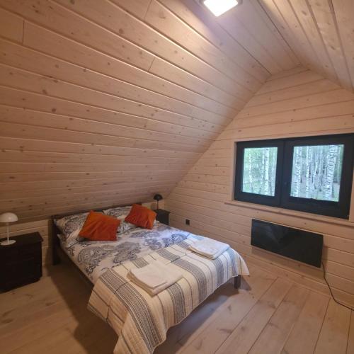 a bedroom with a bed in a log cabin at Leśne Klimaty in Smolniki