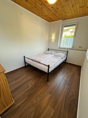a small bedroom with a bed and a window at Emília apartman in Balatonszemes