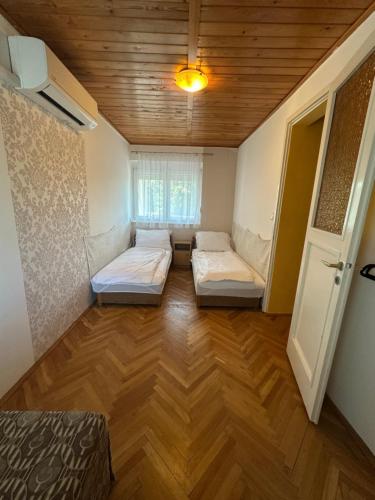 a room with two beds in the middle of a room at Emília apartman in Balatonszemes