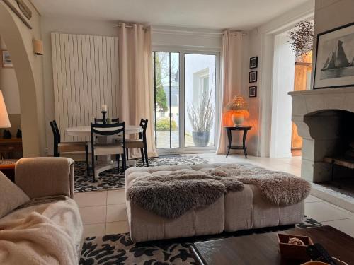 a living room with a couch and a fireplace at La petite duchesse - jaccuzzi in Plérin
