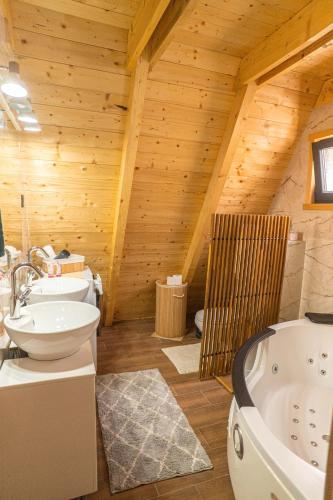 ein Badezimmer mit zwei Waschbecken, einer Toilette und einer Badewanne in der Unterkunft Vila Markizo in Barajevo