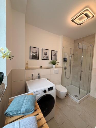 a bathroom with a shower and a washing machine at Herzstück in Ansbach