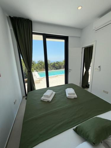 a bedroom with a green bed with a view of the ocean at Green House in Perazića Do